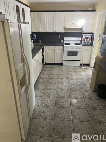 Miami Gardens house for rent - A kitchen with white appliances and cabinets.