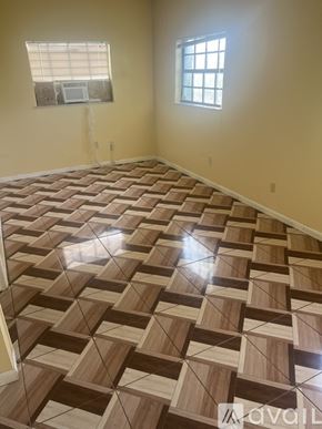 Miami Gardens house for rent - A room with a wooden floor and two windows.
