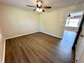 Taylors house for rent - A room with a ceiling fan and wooden flooring.
