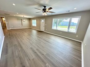 Taylors house for rent - A spacious room with a ceiling fan and wooden flooring.