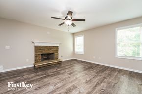 Jefferson house for rent - A spacious room with a fireplace and a ceiling fan.
