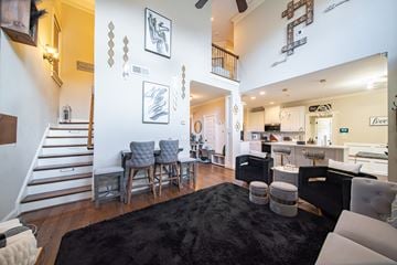Midland house for rent - A living room with a black rug and a staircase.
