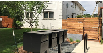 Dallas apartment for rent - A black mailbox is on the sidewalk in front of a house.