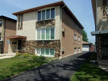Calumet City apartment for rent - A long brick building with a stone pillar in the middle of it.
