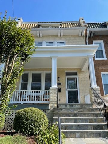 Washington apartment for rent - A house with a white porch and a black staircase.