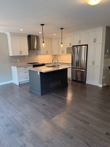 London house for rent - A kitchen with a wooden floor and a stainless steel refrigerator.