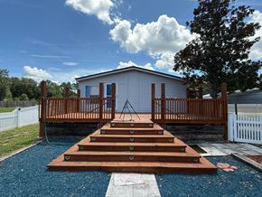Interlachen house for rent - A wooden staircase leads up to a small white building with a porch.