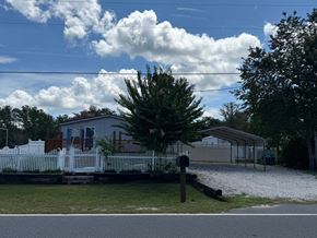 Interlachen house for rent - A house with a white picket fence and a tree in front.