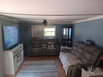 Interlachen house for rent - A living room with a grey sofa and a television.
