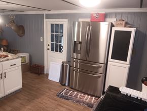 Interlachen house for rent - A kitchen with a stainless steel refrigerator and a black stove top.