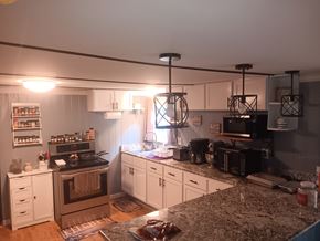Interlachen house for rent - A kitchen with a granite countertop and white cabinets.