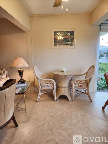 Naples condo for rent - A living room with a sofa, chairs, and a painting on the wall.