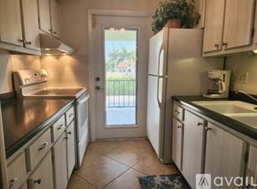 Naples condo for rent - A kitchen with wooden cabinets and a tiled floor.