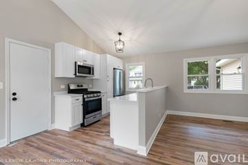Naperville house for rent - A kitchen with white cabinets and a wooden floor.