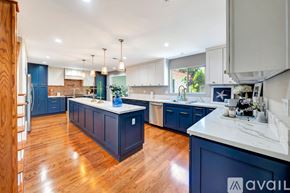 Los Angeles house for rent - A kitchen with dark blue cabinets and wooden floors.