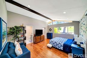 Los Angeles house for rent - A bedroom with a blue couch and a bed with a blue comforter.