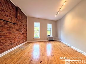 Chicago apartment for rent - A black wood stove is in a room with a brick wall.