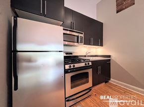 Chicago apartment for rent - A kitchen with black appliances and white countertops.
