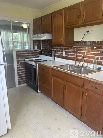 Germantown house for rent - A kitchen with wooden cabinets and a brick backsplash.