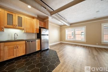Portland apartment for rent - A kitchen with wooden cabinets and a black tile floor.