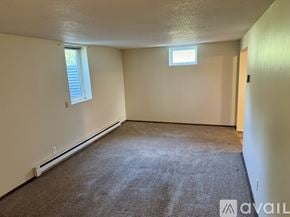 Cokato apartment for rent - A room with a carpeted floor, a window with blinds, and a door.
