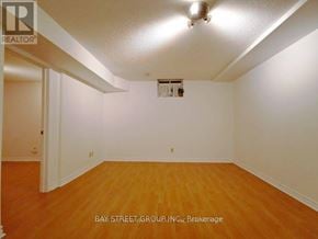 Toronto (Rouge) house for rent - A room with wooden floors and white walls.
