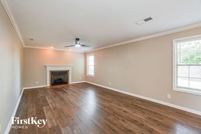 Clarksville house for rent - A spacious room with a fireplace and wood flooring.