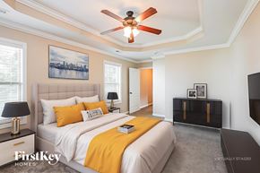 Clarksville house for rent - A bedroom with a bed, a ceiling fan, and a painting on the wall.