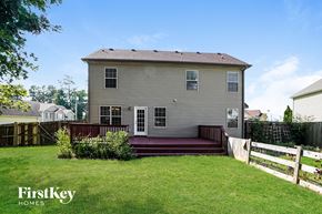 Clarksville house for rent - A house with a grey exterior and a red deck in the foreground.