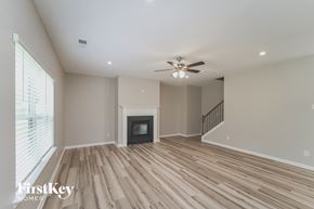 Kannapolis house for rent - A spacious living room with wooden flooring and a fireplace.