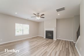 Kannapolis house for rent - A spacious room with a fireplace and wooden flooring.