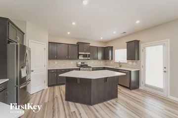 Kannapolis house for rent - A modern kitchen with dark wood cabinets and a white island.