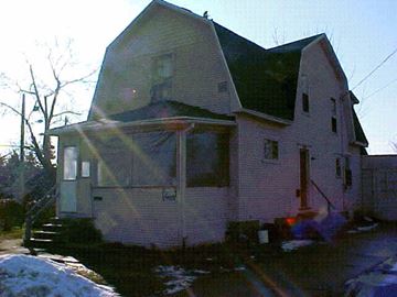 Lansing apartment for rent - A house with a green roof and a red door.