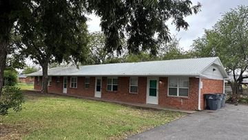 Lawton apartment for rent - A small brick building with a green door and a green roof.