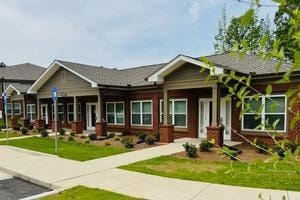 Macon apartment for rent - A row of houses with a blue sign on the first one.