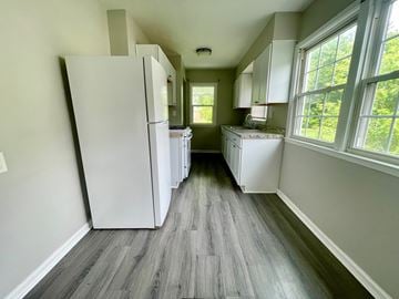 Louisville house for rent - A kitchen with a white refrigerator and wooden floors.