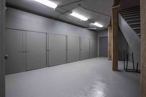 Victoria apartment for rent - A long hallway with grey doors and a concrete floor.