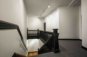 Victoria apartment for rent - A staircase with a black railing and wooden steps.