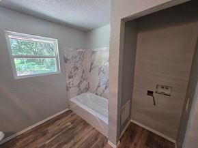 Harrah house for rent - A bathroom with a tub and a window.