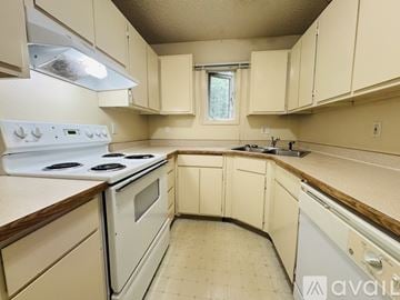 Fairbanks apartment for rent - A kitchen with white appliances and beige cabinets.