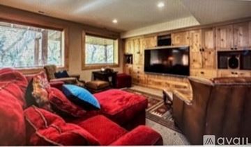 Sandy house for rent - A living room with a red couch and a wooden wall.