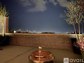 Chicago condo for rent - A balcony with a hot tub and a view of the city at night.