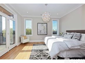 Chicago condo for rent - A bedroom with a large bed and a chandelier.