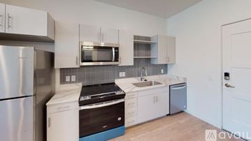 Salt Lake City apartment for rent - A kitchen with white cabinets and a stainless steel refrigerator.