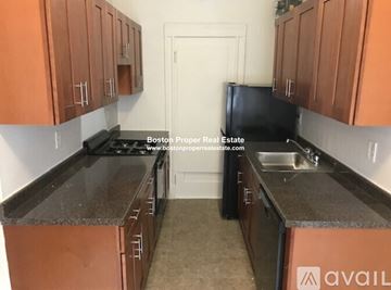 Boston apartment for rent - A kitchen with brown cabinets and a black refrigerator.