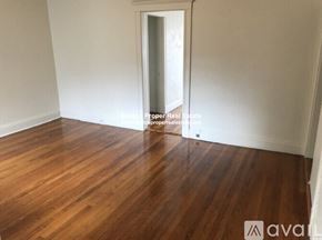 Boston apartment for rent - A room with wooden flooring and a doorway leading to another room.