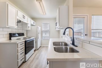 Killeen apartment for rent - A kitchen with white cabinets and a stove top oven.