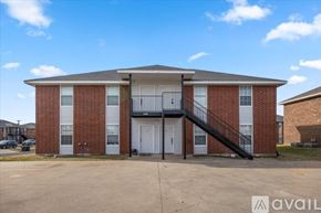 Killeen apartment for rent - A red brick apartment building with a black metal staircase leading to the second floor.