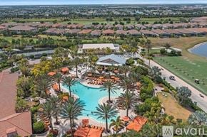 Bradenton condo for rent - A bird's eye view of a resort with a pool and palm trees.