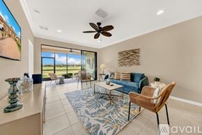 Bradenton condo for rent - A living room with a ceiling fan and a view of the outdoors through the windows.